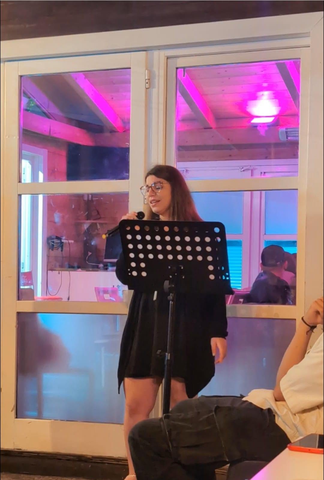 Sarina canta al microfono durante una serata musicale